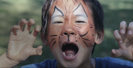 Kid with tiger face paint roaring