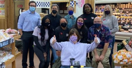 Group of people pose for photo at Trader Joe's grocery store